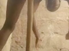 mujer africana se masturba con un palo de escoba.